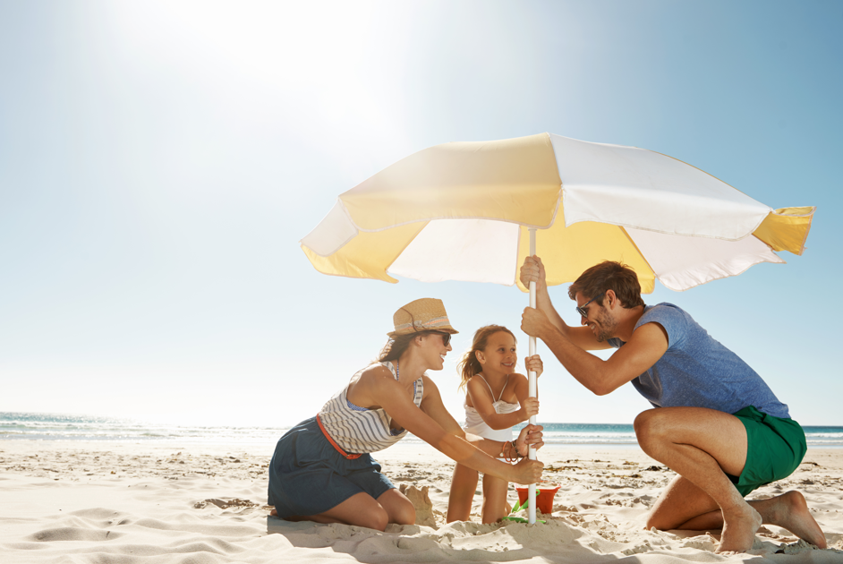 Family putting up umbrella at the beach