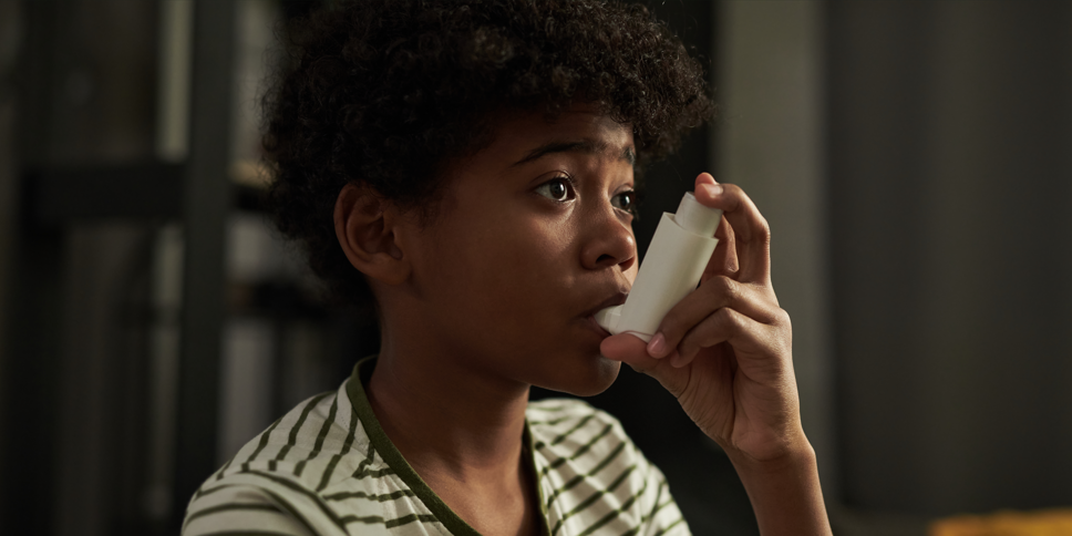 Young boy with asthma using an inhaler