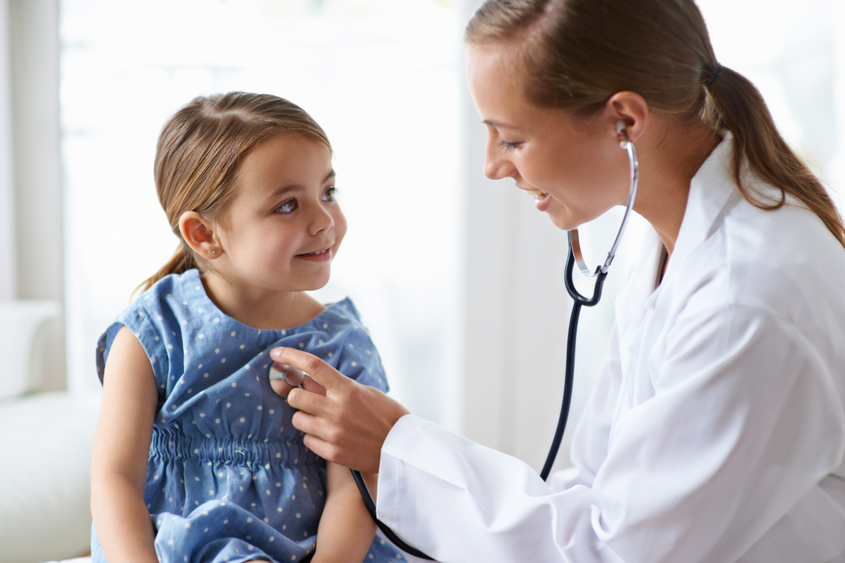 Doctor checking young girl's hearbeat with stethescope