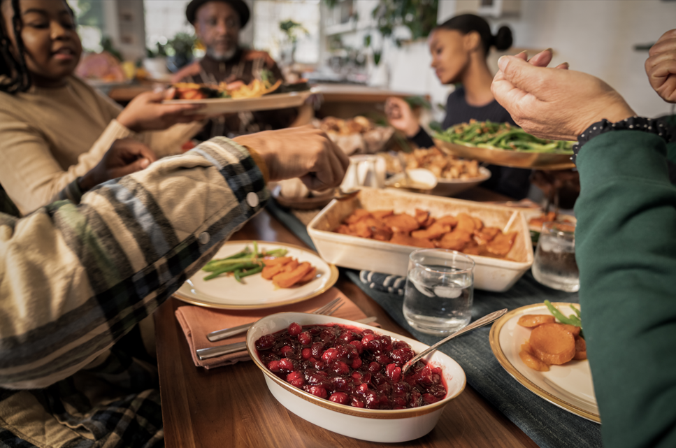 Family passing food around table.