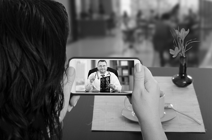 Woman talking with doctor via telehealth on her phone