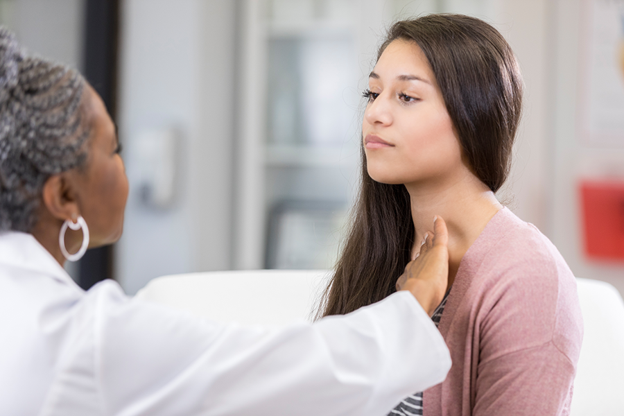 Young woman being examined by female doctor.